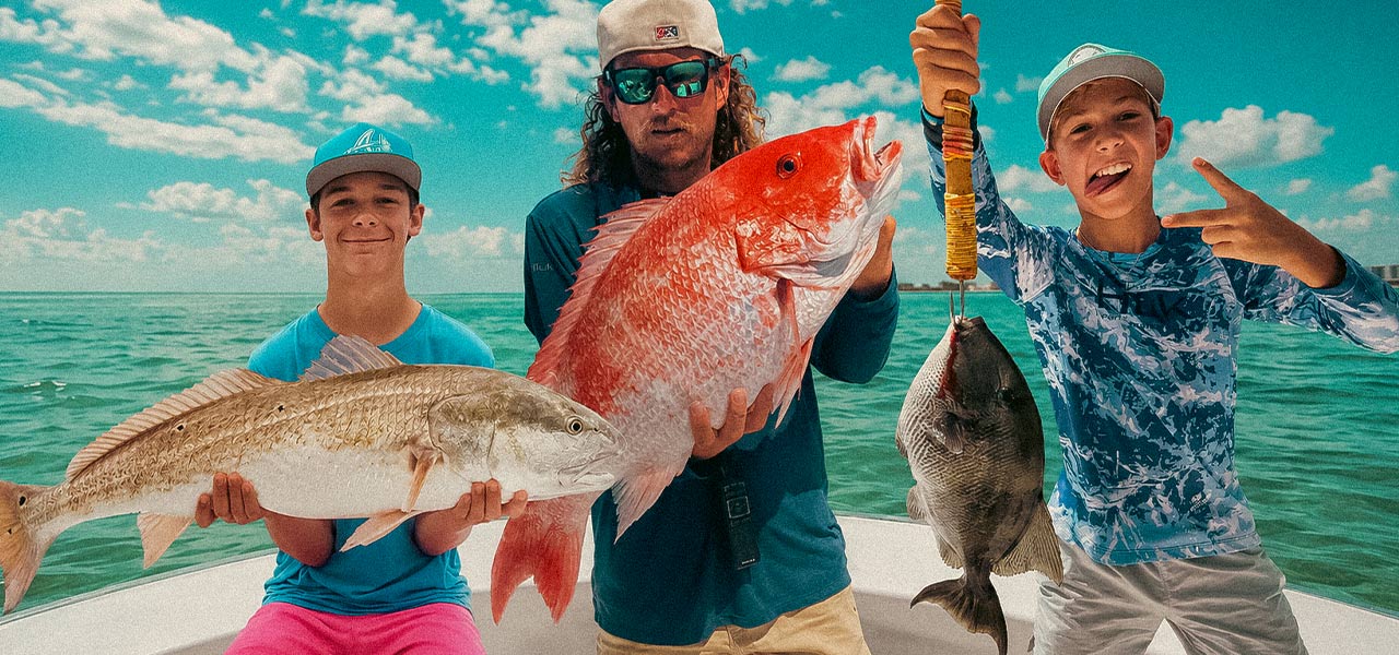 Family holding their catches aboard the Destin inshore fishing boat